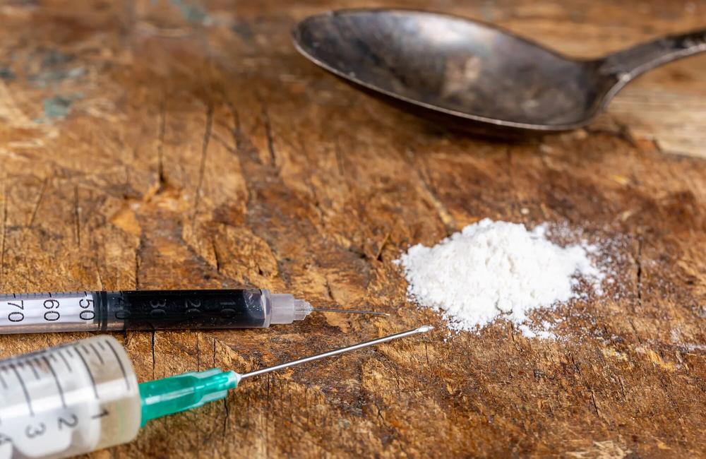 Image by Marco Verch. Creative Commons licence. Two syringes, powder and spoon on old wooden background.