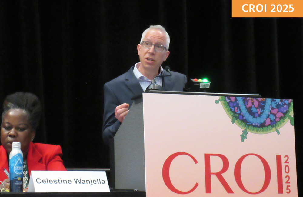 Dr Mark Siedner presenting at CROI 2025. He is standing behind a lectern talking into a microphone.