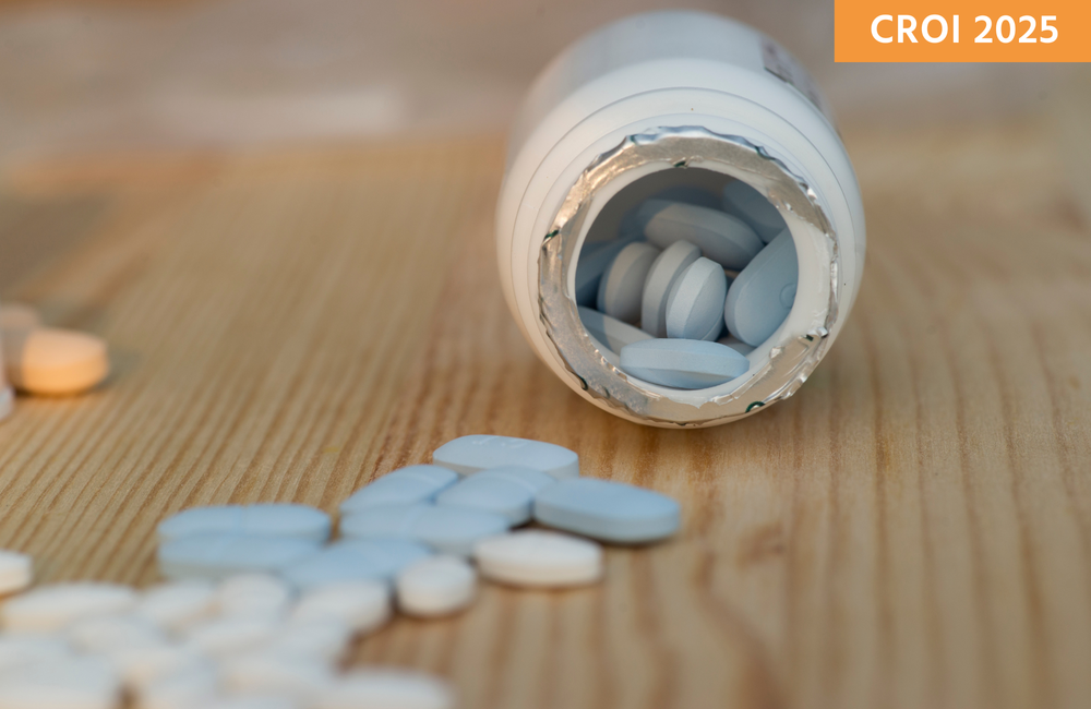 A bottle of blue pills is spilling out onto a table.